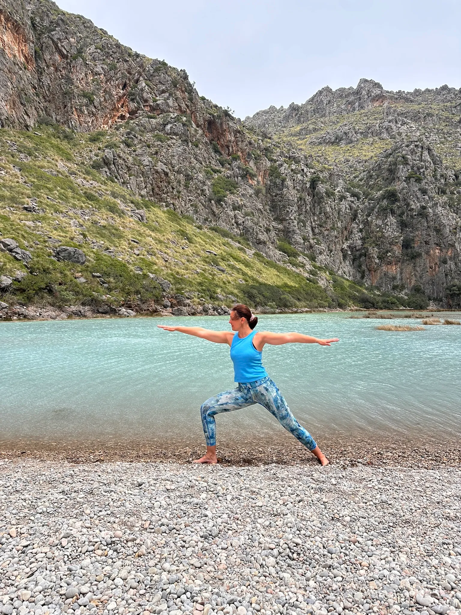 Diana practicing yoga beside a mountain lake